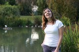 Joyful Woman Laughing by a Tranquil Park Pond