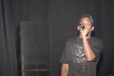 Man with a Microphone Takes the Stage in Black T-Shirt