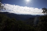 Sunburst Over Forested Mountain Valley in Winter