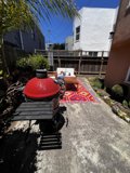 Red BBQ Grill in a Lush Backyard Setting