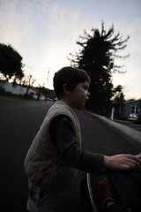 Young Boy Skateboarding at Dusk in Suburban Neighborhood