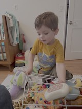 Young Boy Playing with Toy Shopping Cart