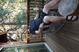 Man Relaxing on Wooden Deck Among Trees