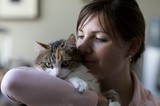 Woman Tenderly Nuzzles Her Tabby Cat Indoors