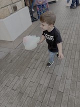 Young Boy Enjoying Cotton Candy Outdoors