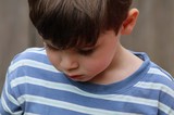 Young Boy in Blue Striped Shirt Looking Down