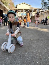 Young Child on Balance Bike at Neighborhood Party