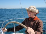 Woman at the Helm on a Sunny Sailing Day