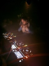 DJ Performance in Dark Club with Illuminated Controllers