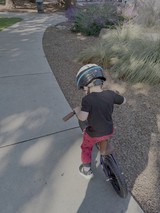 Young Child Learning to Ride Bicycle with Helmet