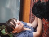 Woman Relaxing on Floor with Black Dog