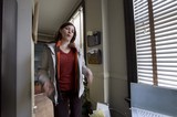 Woman Gesturing Expressively in Sunlit Office Doorway