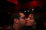 Couple Sharing a Kiss in Red-Lit Bar