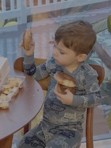 Toddler Enjoying Donuts at Kitchen Table