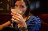 Woman Sipping Cocktail at Dimly Lit Bar