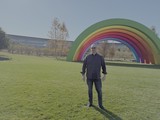 Man Posing with Rainbow Art Installation