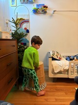Child in Green Dinosaur Pajamas Standing in Bedroom