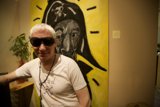 Man in Sunglasses Poses in Front of Artwork