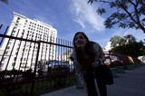 Urban Explorer Leaning at Downtown City Fence