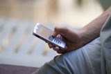 Connected Man Caption: A male adult stays connected with his mobile phone by texting on it, in a 2006 Flexilis shoot.
