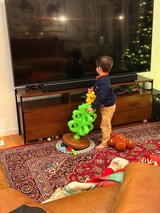 Young Child Playing with Bright Green Toy in Living Room