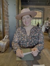 Woman in Wide-Brimmed Hat at Trendy Cafe