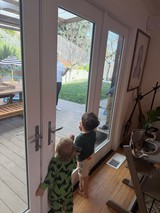 Two Children Watching Parents Work in Backyard