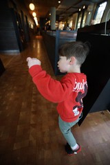 Young Boy Exploring Museum Exhibition in Red Hoodie