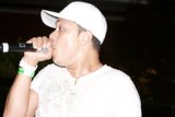 The Entertainer in the White Hat with a Microphone