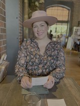 Woman in Floral Top Smiling at Cafe
