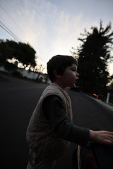 Young Boy on Skateboard at Dusk in Suburban Street