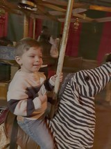 Young Boy Enjoying Carousel Ride on Zebra