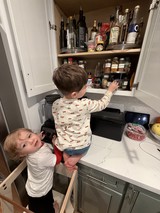 Two Young Boys Exploring Kitchen Cabinet Together