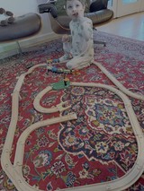 Toddler Playing with Wooden Train Set at Home