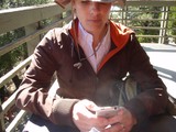 Hiker Checks iPhone on Mountain Trail Bridge