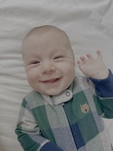 Adorable Baby Waving in Plaid Pajamas