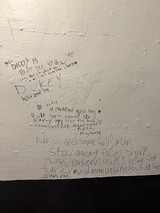 Handwritten Wall Messages in a Bathroom Stall