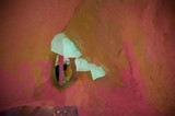 Peeling Paint and Torn Paper in Pink Adobe Wall