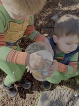 Children Exploring Nature with Glass Container