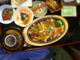A Delicious Spread Caption: A tray filled with an assortment of dishes including soup, stew, bread and vegetables, accompanied by condiments and seasonings, showcased on a beautifully set dining table.