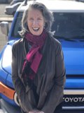 Happy Woman Poses in front of Blue Toyota Truck