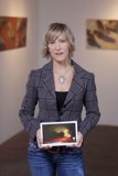 Woman Examining Paintings on Tablet Computer