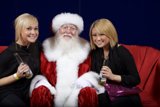 Festive Christmas Gathering Caption: Two women and a man sit on a couch, donning festive clothing and Santa Claus hats, holding glasses and a container of treats, at the 2007 APC Christmas party.
