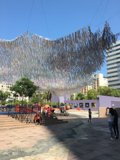 Hanging Paper Sculpture Overlooks Vibrant City Plaza