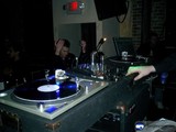Spinning the Beats Caption: A DJ entertains the crowd with his turntable and speaker set up at a lively music event.