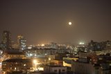 The Bright Lights of the Metropolis Under a Full Moon