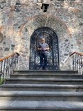 Man Standing at Stone Building Entrance