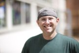 Smiling Man in Cap and Glasses