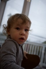 Curious Toddler with Wavy Hair Indoors