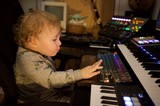 Young Child Exploring Music Production Equipment at Night